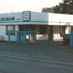 eine Werkseinfahrt, auf dem Gebäude steht Kunststofftechnik F.&H. Riesselmann GmbH