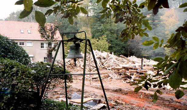 Abrissarbeiten der Tobiasmühle, ein Schutthaufen, davor steht eine Glocke