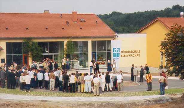viele Menschen sind vor dem neuen Gebäude versammelt, an der gelben Fassade steh Förderschule Kleinwachau